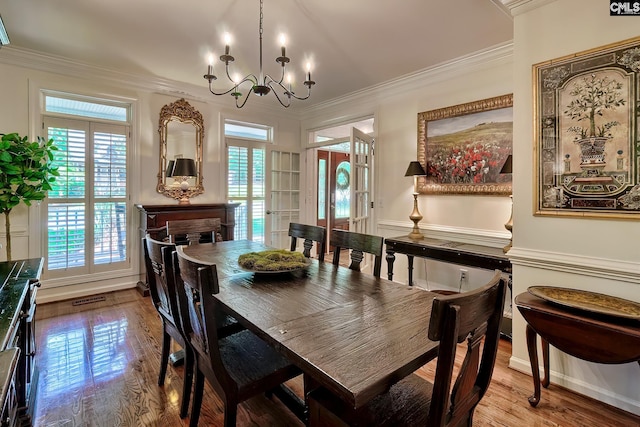 dining room featuring crown molding, a chandelier, wood finished floors, and french doors