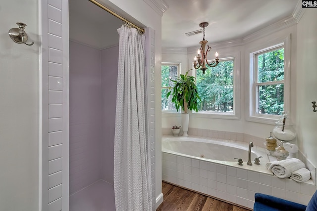full bath with wood finished floors, a jetted tub, a tile shower, a chandelier, and crown molding