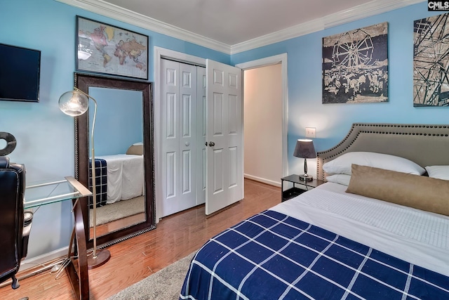 bedroom with crown molding, wood finished floors, and a closet