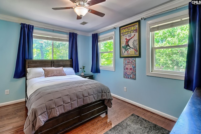 bedroom with crown molding, baseboards, wood finished floors, and a ceiling fan