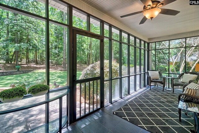 sunroom / solarium featuring a ceiling fan