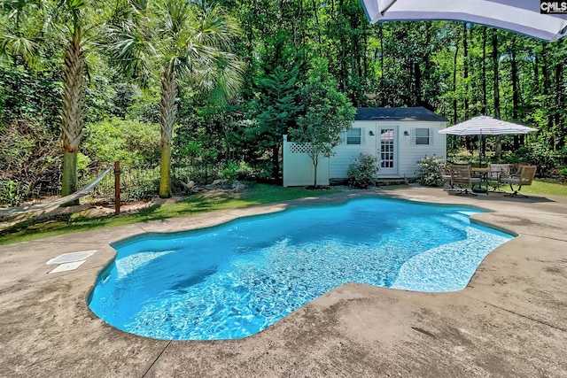 outdoor pool featuring a patio, an outbuilding, and an exterior structure