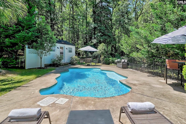 view of pool with a patio area, an outdoor structure, and fence