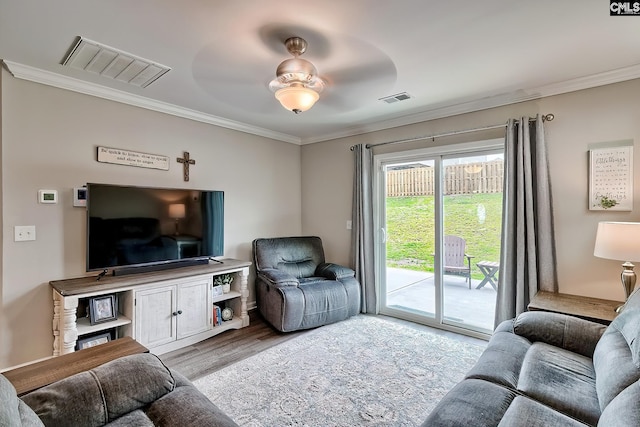 living area with crown molding and wood finished floors
