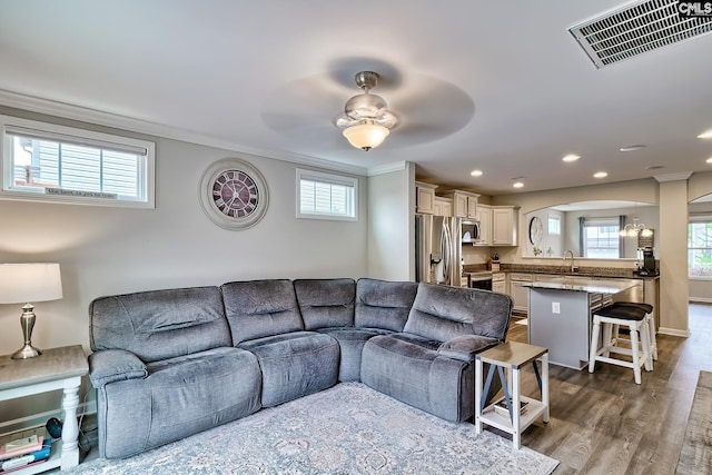 living room with ornamental molding, dark wood-style floors, recessed lighting, ceiling fan, and healthy amount of natural light