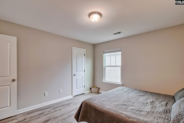 bedroom with light wood finished floors and baseboards