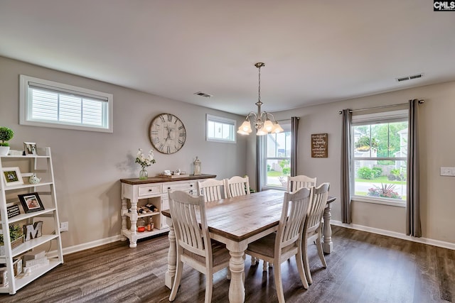 dining space with dark wood-style floors, a chandelier, and baseboards