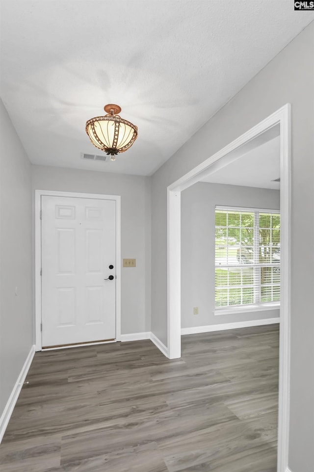entrance foyer with baseboards and wood finished floors