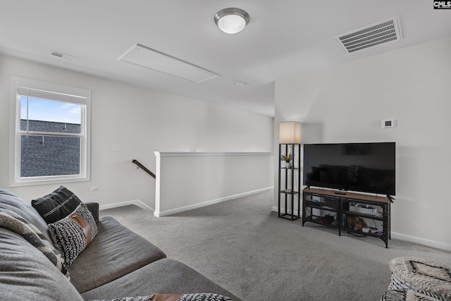 living room with attic access, carpet floors, and baseboards