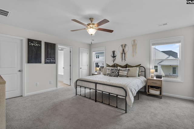 carpeted bedroom featuring multiple windows, baseboards, connected bathroom, and a ceiling fan