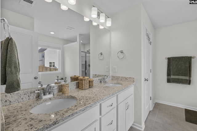 full bathroom featuring tile patterned flooring, baseboards, and double vanity