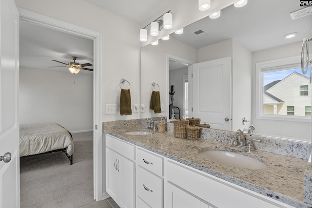 bathroom with ceiling fan, double vanity, ensuite bath, and baseboards
