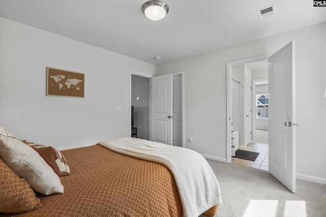 bedroom with light colored carpet, baseboards, and light tile patterned floors