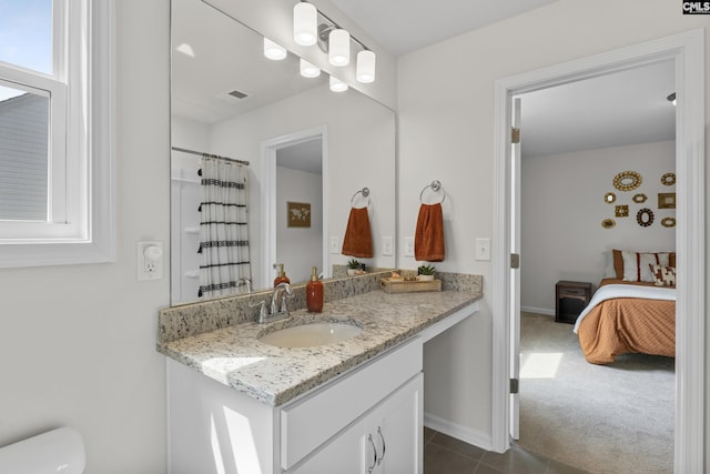 bathroom featuring vanity, toilet, tile patterned flooring, ensuite bathroom, and baseboards
