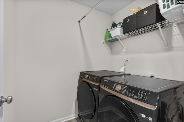 laundry room with washer and dryer and baseboards