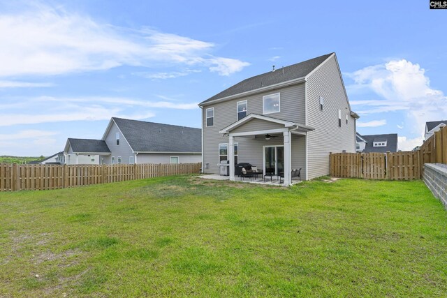 rear view of property featuring a ceiling fan and a patio