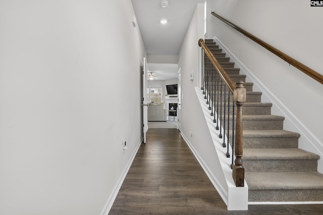 stairway featuring wood finished floors, a ceiling fan, baseboards, and recessed lighting