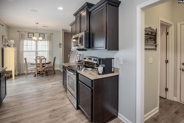 kitchen featuring appliances with stainless steel finishes, a chandelier, light wood finished floors, dark brown cabinets, and recessed lighting