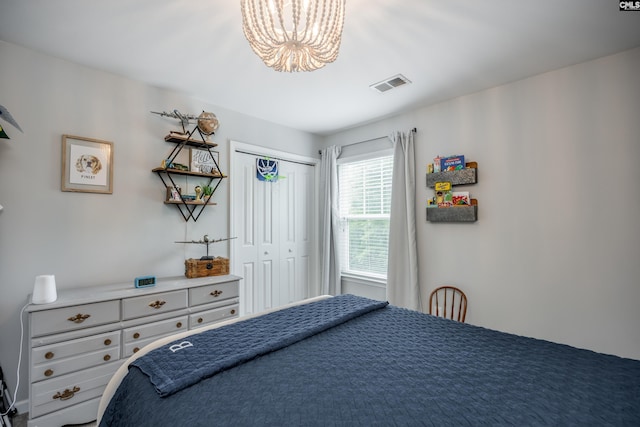 bedroom featuring a chandelier and a closet