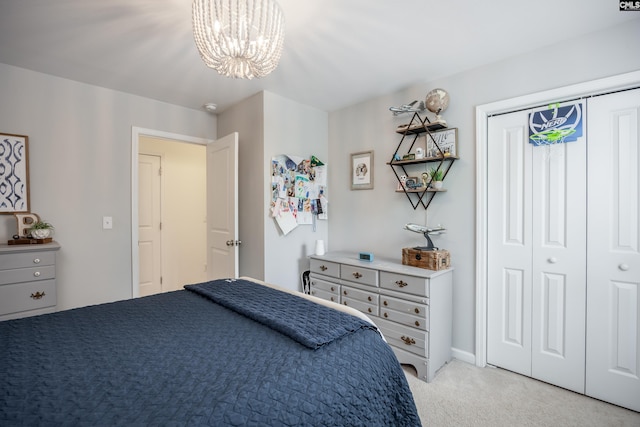 bedroom featuring light colored carpet, a chandelier, and a closet