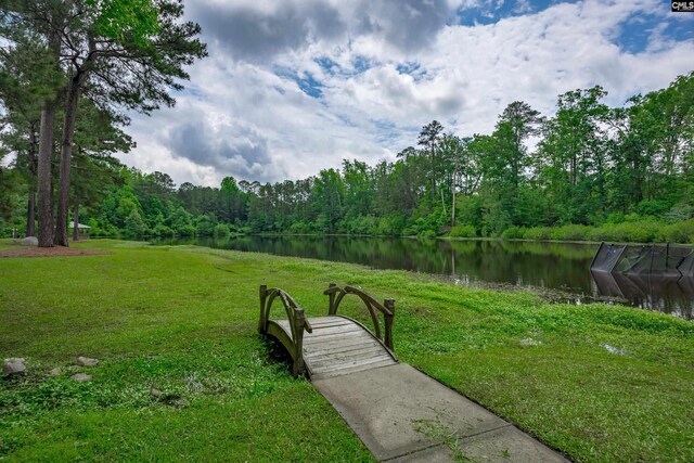 surrounding community with a wooded view, a water view, and a yard
