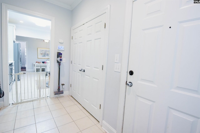 hall with light tile patterned flooring, baseboards, and ornamental molding