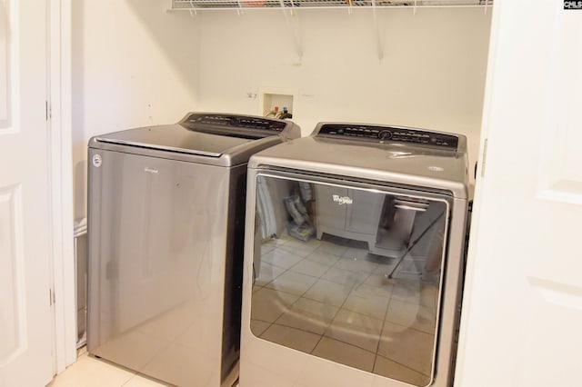 laundry room featuring separate washer and dryer and tile patterned flooring
