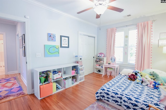 bedroom with wood finished floors, ornamental molding, ceiling fan, and baseboards