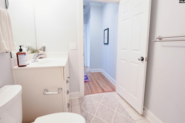 bathroom featuring toilet, vanity, tile patterned floors, and baseboards