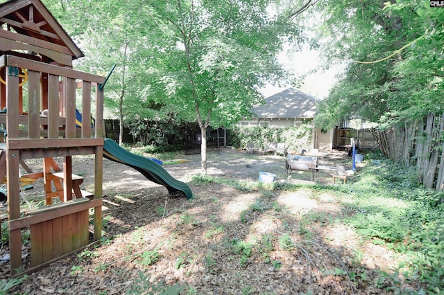 fenced backyard featuring a playground