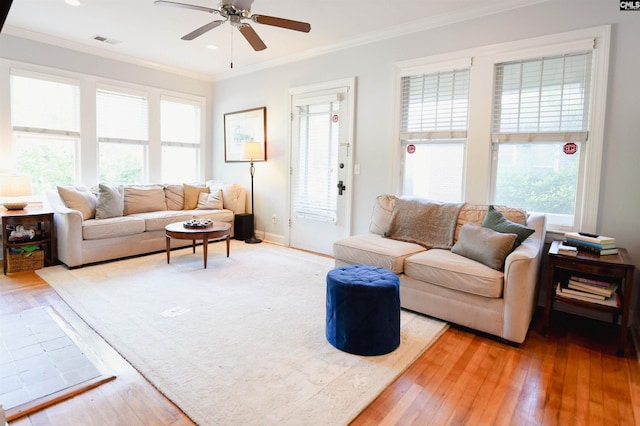 living room with ceiling fan, ornamental molding, hardwood / wood-style flooring, and baseboards