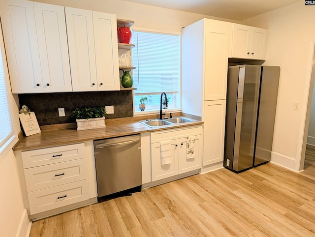 kitchen with stainless steel appliances, a sink, light wood-type flooring, and open shelves