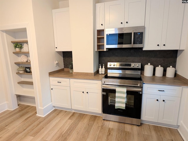 kitchen featuring stainless steel appliances, open shelves, light wood finished floors, and white cabinets