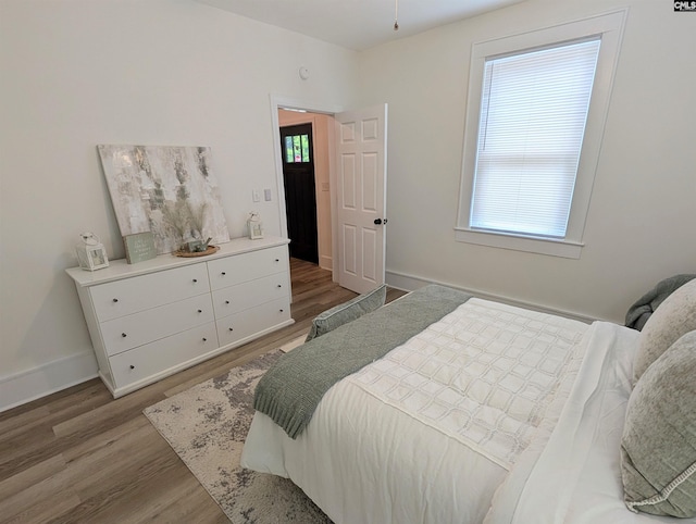 bedroom featuring wood finished floors and baseboards