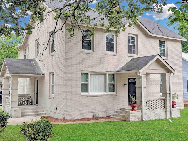 view of front of home with a front lawn, brick siding, and crawl space