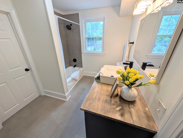 bathroom with vanity, baseboards, tile patterned flooring, and shower / bath combination