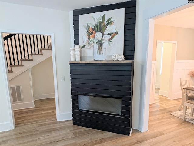 detailed view of wood finished floors and a glass covered fireplace