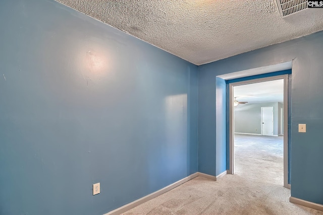 carpeted empty room featuring baseboards and a textured ceiling