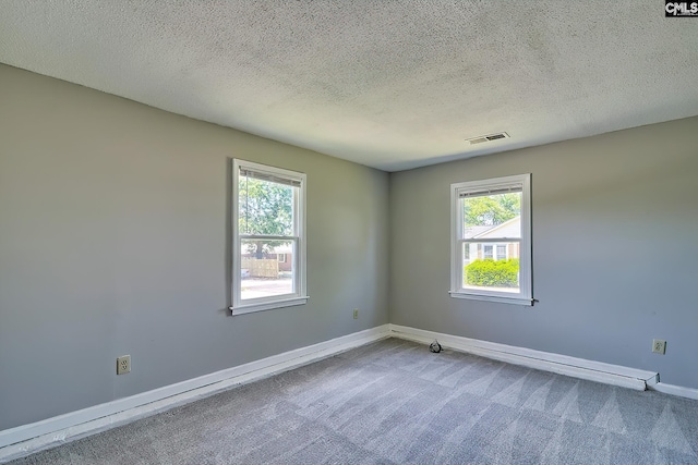 spare room featuring carpet flooring, baseboards, and a textured ceiling