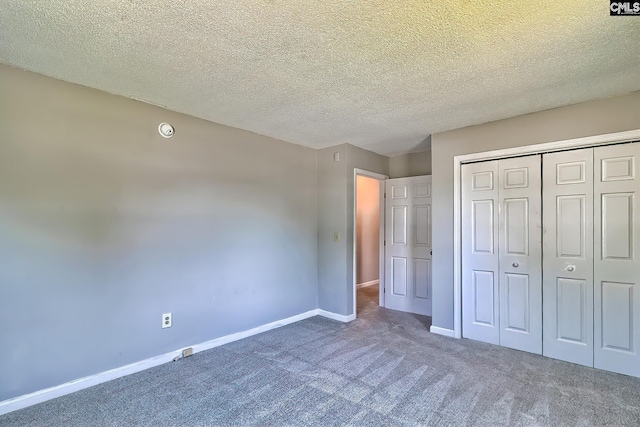 unfurnished bedroom featuring carpet floors, a closet, baseboards, and a textured ceiling