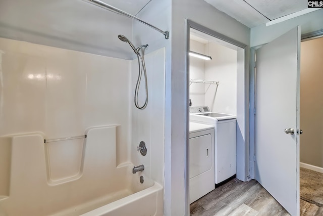 bathroom featuring wood finished floors, washer and dryer, and shower / washtub combination