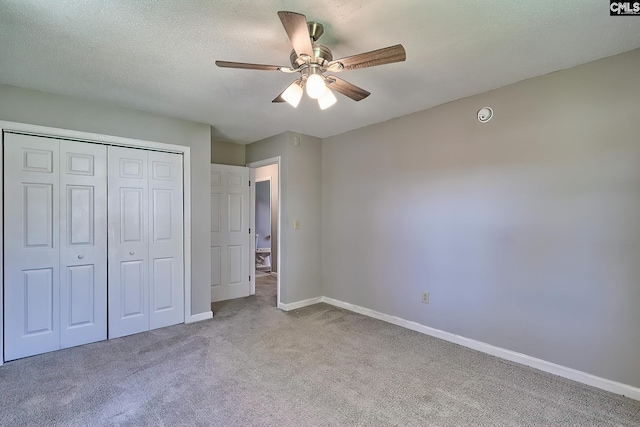 unfurnished bedroom with carpet floors, baseboards, a closet, and a ceiling fan