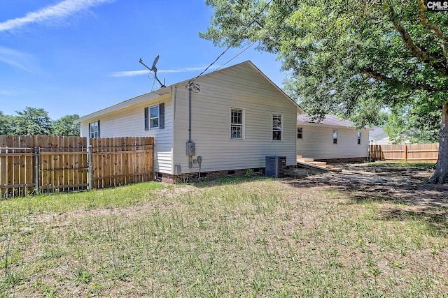 back of property featuring crawl space, fence, and central AC