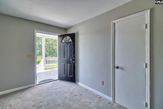 entryway featuring baseboards and carpet