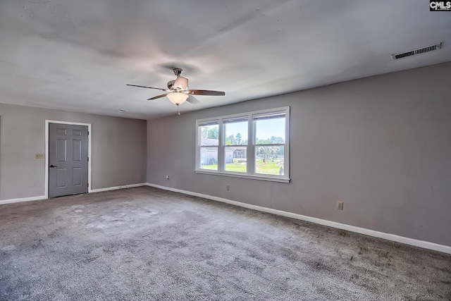 carpeted spare room with ceiling fan and baseboards