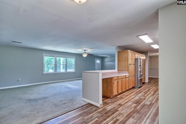 kitchen with high end refrigerator, baseboards, light wood-type flooring, light countertops, and ceiling fan