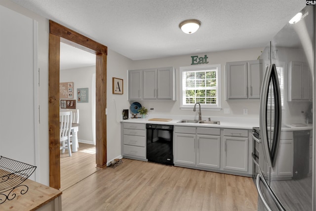 117 Rosewood Ln, Lexington, SC 29072 - kitchen with freestanding refrigerator, black dishwasher, a sink, light wood-type flooring, and a textured ceiling
