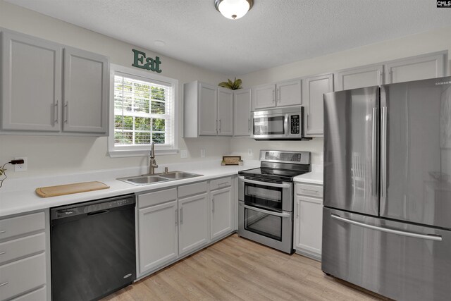 117 Rosewood Ln, Lexington, SC 29072 - kitchen featuring stainless steel appliances, a sink, light countertops, light wood finished floors, and a textured ceiling
