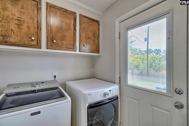 clothes washing area with independent washer and dryer, cabinet space, and plenty of natural light