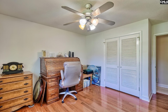 office space featuring light wood finished floors, ceiling fan, and baseboards